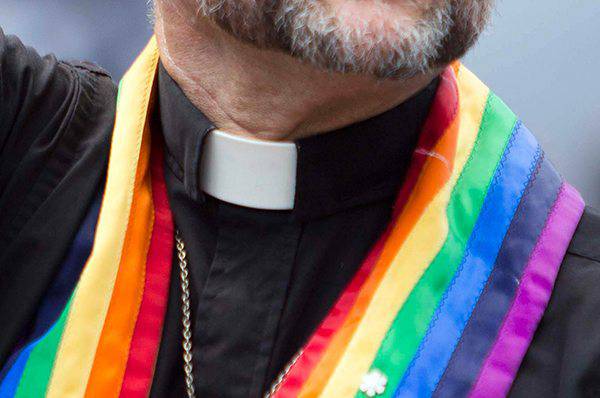 Un prete indossa una stola arcobaleno, simbolo del Gay Pride