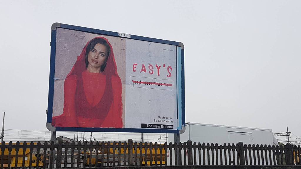 Uno dei cartelloni pubblicitari censurati con la modella rivestita e la scritta sgrammaticata